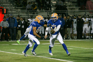 QB Alec Fidan hands of to a Sandburg player in 1st half. Sandburg defeats Joliet West 35-14 Friday Oct. 9, 2015. Copyright (C) Steve Neuhaus 2015. All Rights Reserved