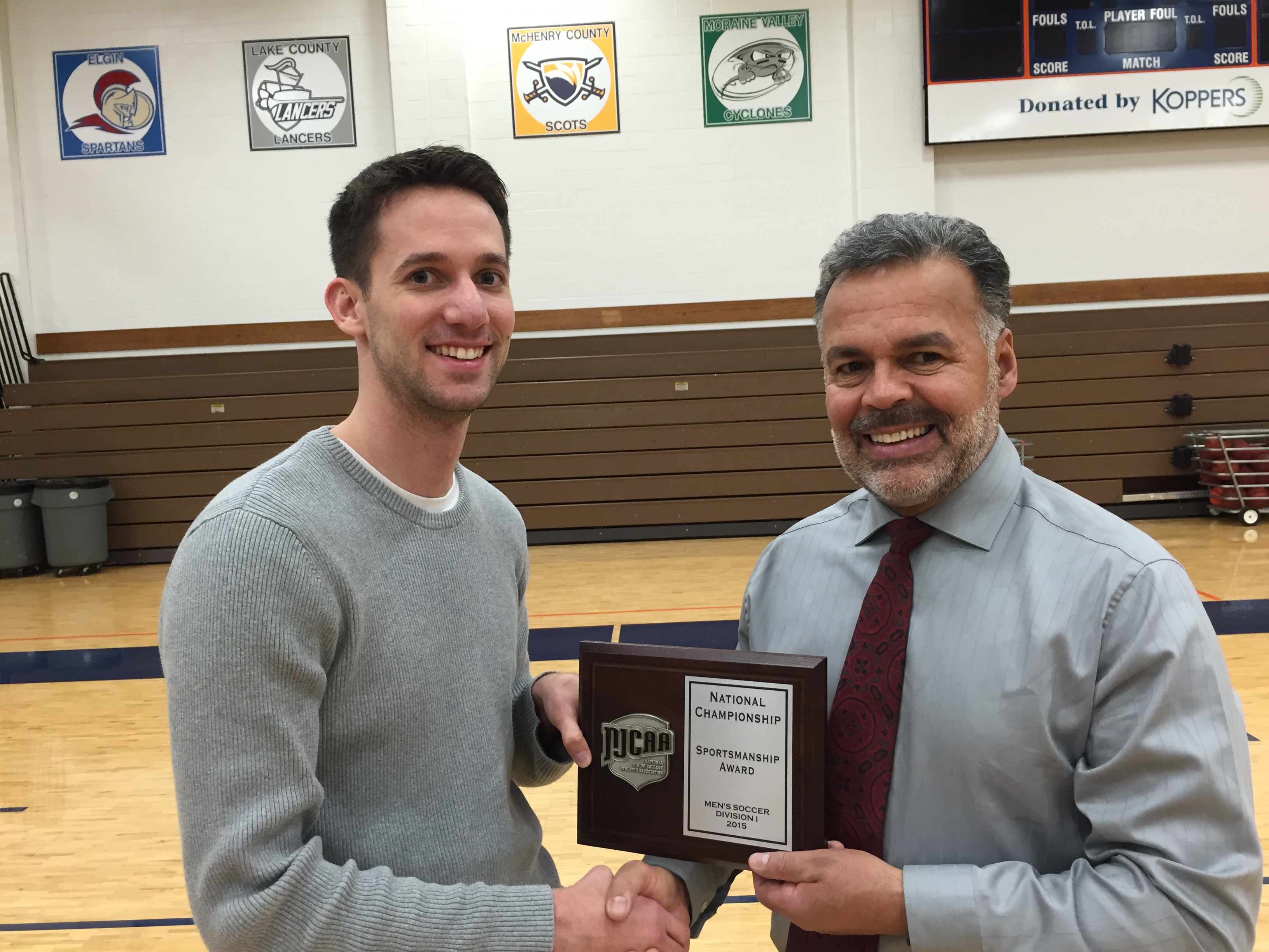 Assistant athletic director Joe Belcaster (at left) congratulates men’s soccer coach Juan Franco on his team’s receiving the NJCAA Sportsmanship Award. The award goes to the team judged by the tournament committee to be the most sportsmanlike at the NJCAA Division I national men’s soccer tournament. (Jim O’Connell/Morton College)