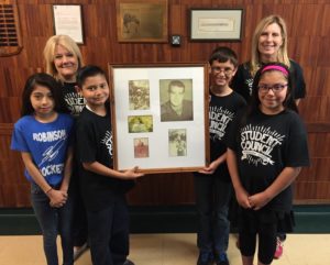 Gisselle Garcia, teacher Mary Doyle, Angel Castro, Kyle Lyth, teacher Dee Mutters and Emily Aguero, left to right, with photos of the late Sgt. James Robinson, Jr., who died a hero in Vietnam.