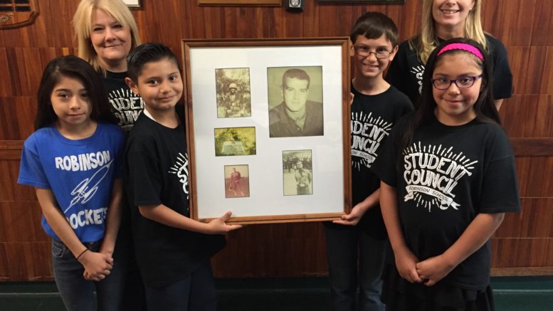 Gisselle Garcia, teacher Mary Doyle, Angel Castro, Kyle Lyth, teacher Dee Mutters and Emily Aguero, left to right, with photos of the late Sgt. James Robinson, Jr., who died a hero in Vietnam.