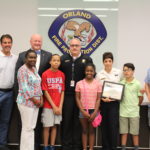 From left OFPD Trustee Blair Rhode, Trustee John Brudnak, Cortez’s mother, Cortez, Fire Chief Michael Schofield, Cortez’s sister Taylor, Sgt. Cindy Guerra, Cindy’s son Joseph, and OFPD Trustee Jim Hickey.